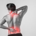 Close up of man rubbing his painful back isolated on white backg